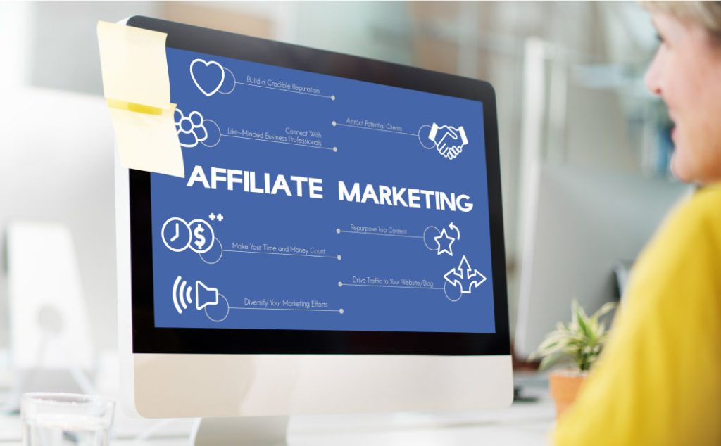 A person looking at a computer screen with a blue background and white text that reads ‘Affiliate Marketing’