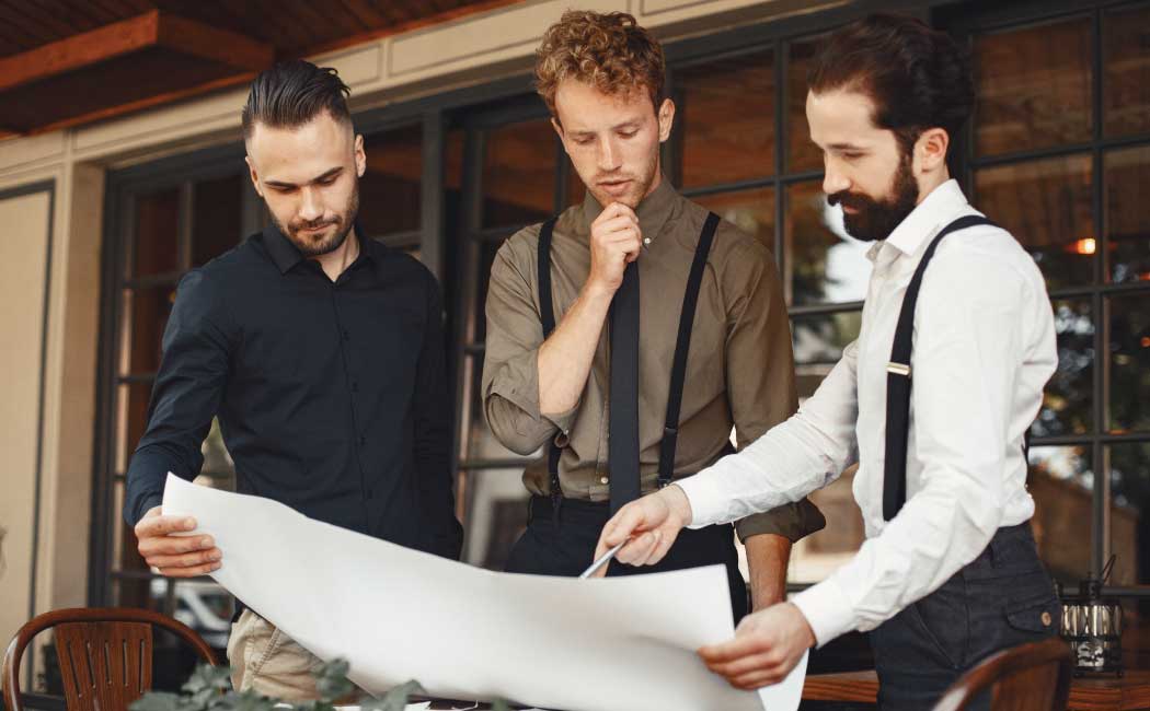 Three people stand outside the clothing store and discuss the business plan