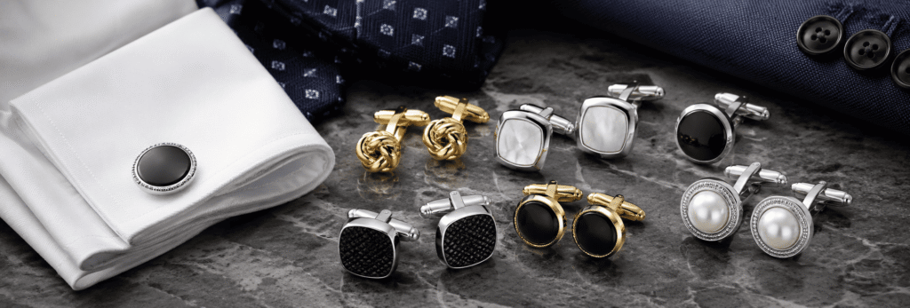 Premium silver, black, gold, and pearl cufflinks displayed beside formal shirt cuffs.
