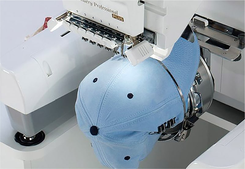 A baseball cap is being embroidered on a sewing machine 