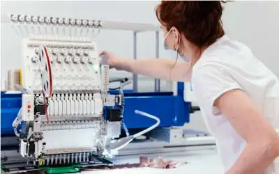 A woman is using an embroidery machine