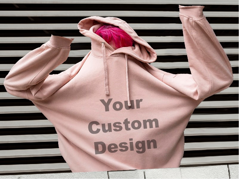 A person is wearing a pink hoodie with a custom design on it.