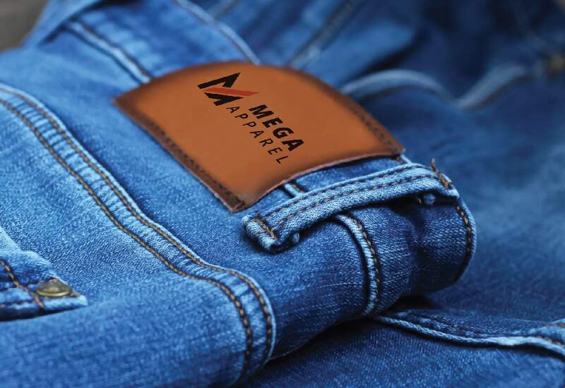 Close-up of a pair of blue jeans with the Mega Apparel logo on the label