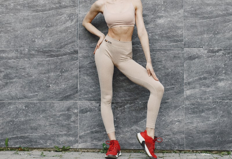 A woman is wearing seamless leggings in front of the wall
