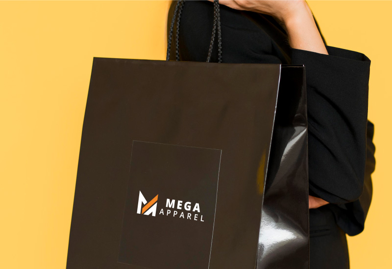  A woman with dark hair and a black jacket smiles as she holds a black shopping bag