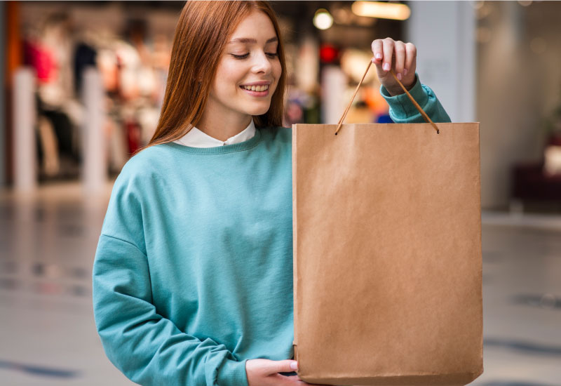  A woman is looking at a clothing packaging bag in hand
