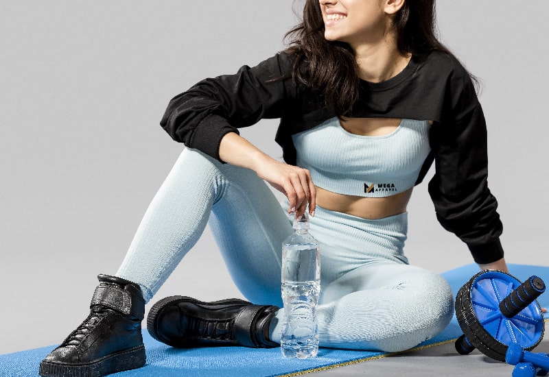A woman is smiling while doing exercise in athletic clothes